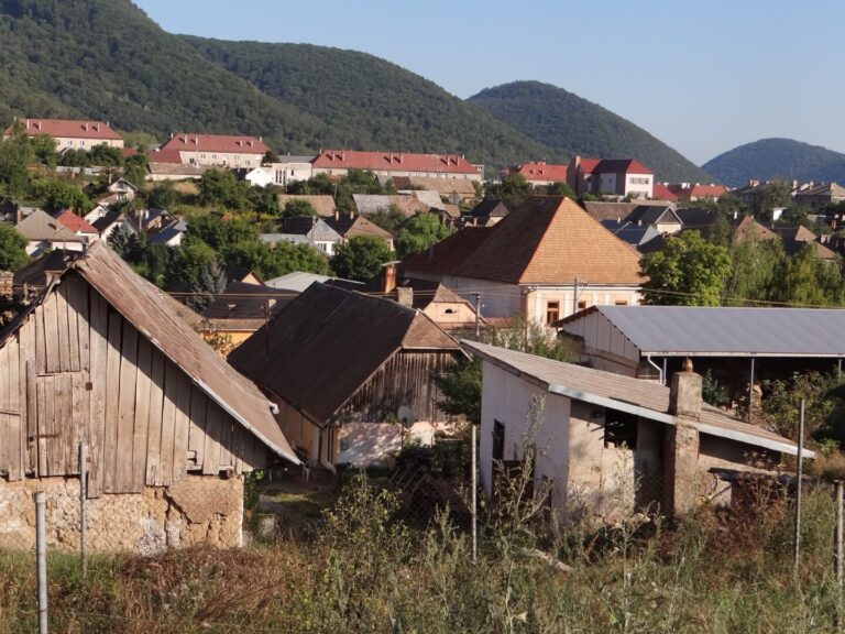Pohľad na Jelšavu s domami a zalesnenými kopcami v pozadí